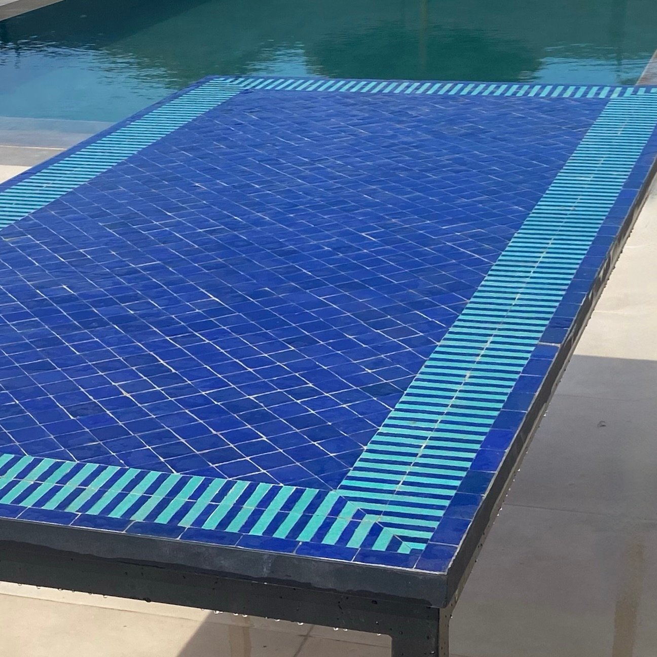 Table zellige bleu blanc rayée bord piscine